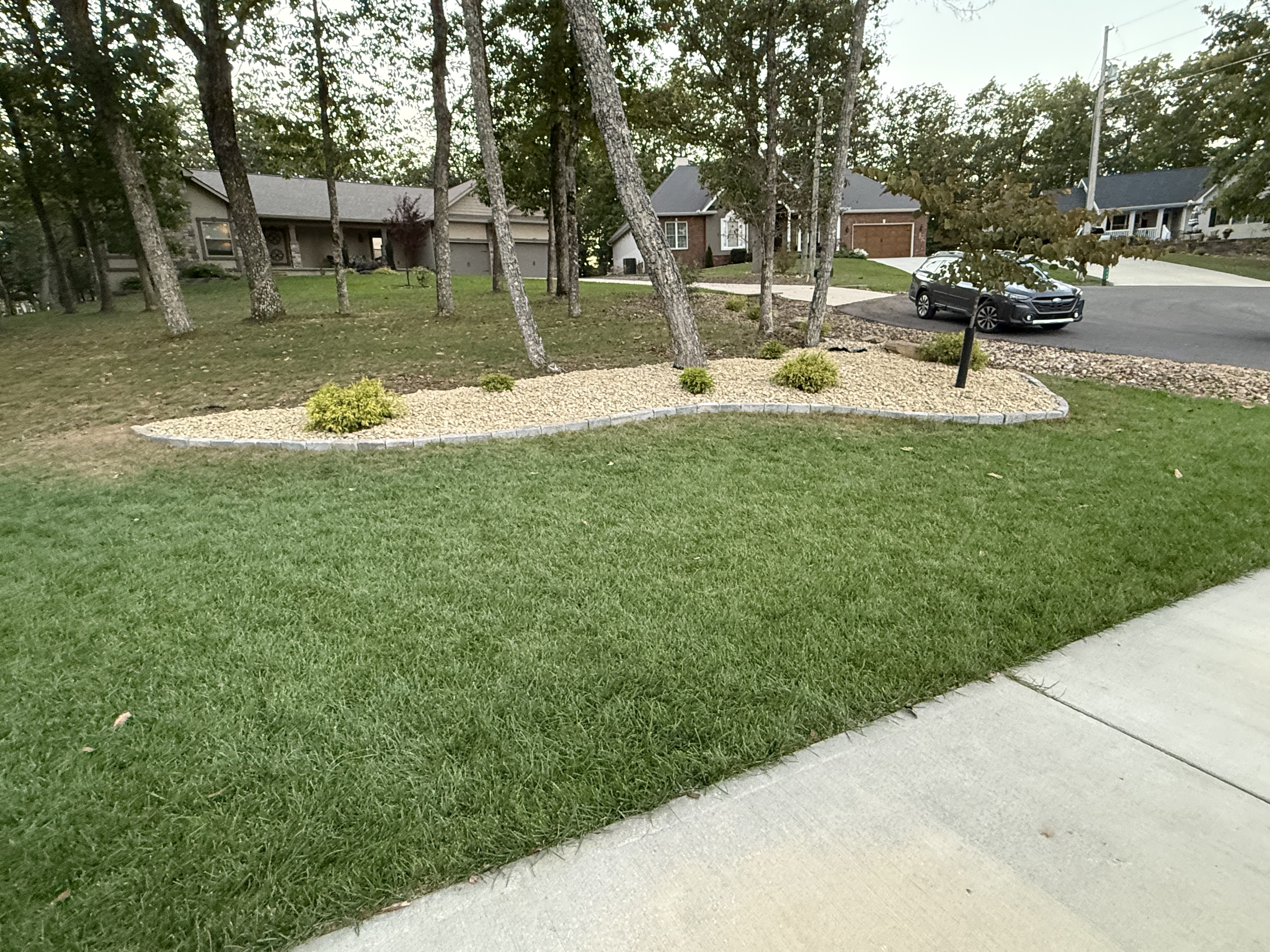 Established turf lawn with stone-bordered planting bed